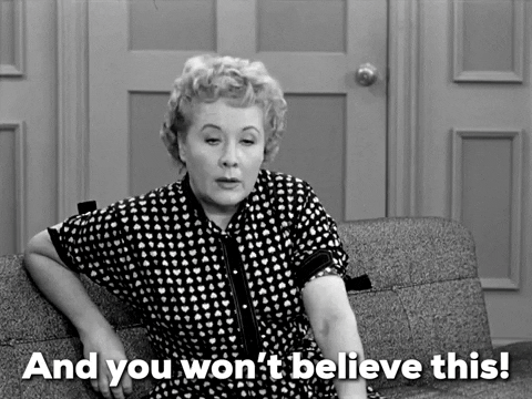 A woman sitting on a couch in a black and white dress says, "And you won't believe this!"