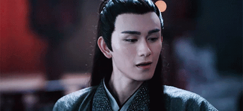Meng Yao from The Untamed Chinese Drama in dark robes smiling darkly