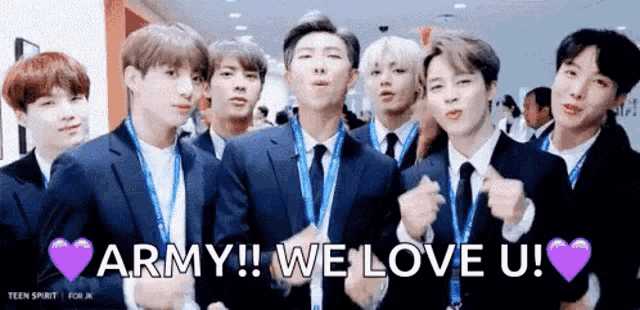 Gif mostra os sete integrantes do BTS sorrindo, fazendo o símbolo de coração com as mãos e dizendo: We love you! A legenda diz: ARMY!! We love u!