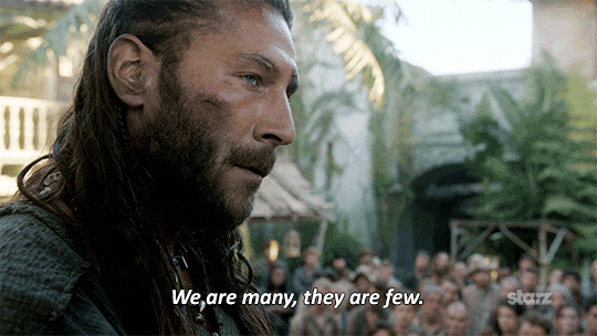A looping gif of the pirate Charles Vane from the tv show Black Sails speaking to a crowd in an open are setting, captioned "We are many, they are few."