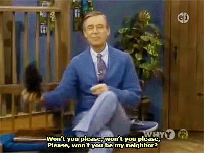 Animated image of Fred Rogers on the set of his TV show Mister Rogers' Neighborhood. He is sitting on a bench, wearing a blue cardigan, and tossing his shoe from his right hand to his left. The captioned text reads, "Won't you please, won't you please, please won't you be my neighbor."