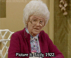 An old woman with white hair, eye glasses, and a red sweater saying, "Picture it: Siciliy, 1922"